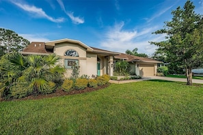 A single-story house with a front porch, a garage, and a well-maintained lawn.