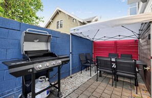 A barbecue grill with a gas tank, a tent, and outdoor seating. - Stylish 3BR Seattle Retreat near UW w/ City Views (Seattle)