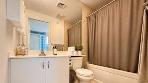 Un baño moderno con inodoro, lavabo y zona de ducha.