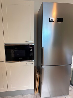 A kitchen with a microwave and a stainless steel refrigerator. - Country house with a pool between Bordeaux and St-Émilion (Croignon)