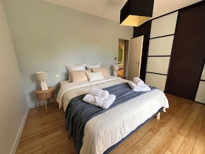 A bedroom with a bed, bedside tables, and a wardrobe. - Country house with a pool between Bordeaux and St-Émilion (Croignon)