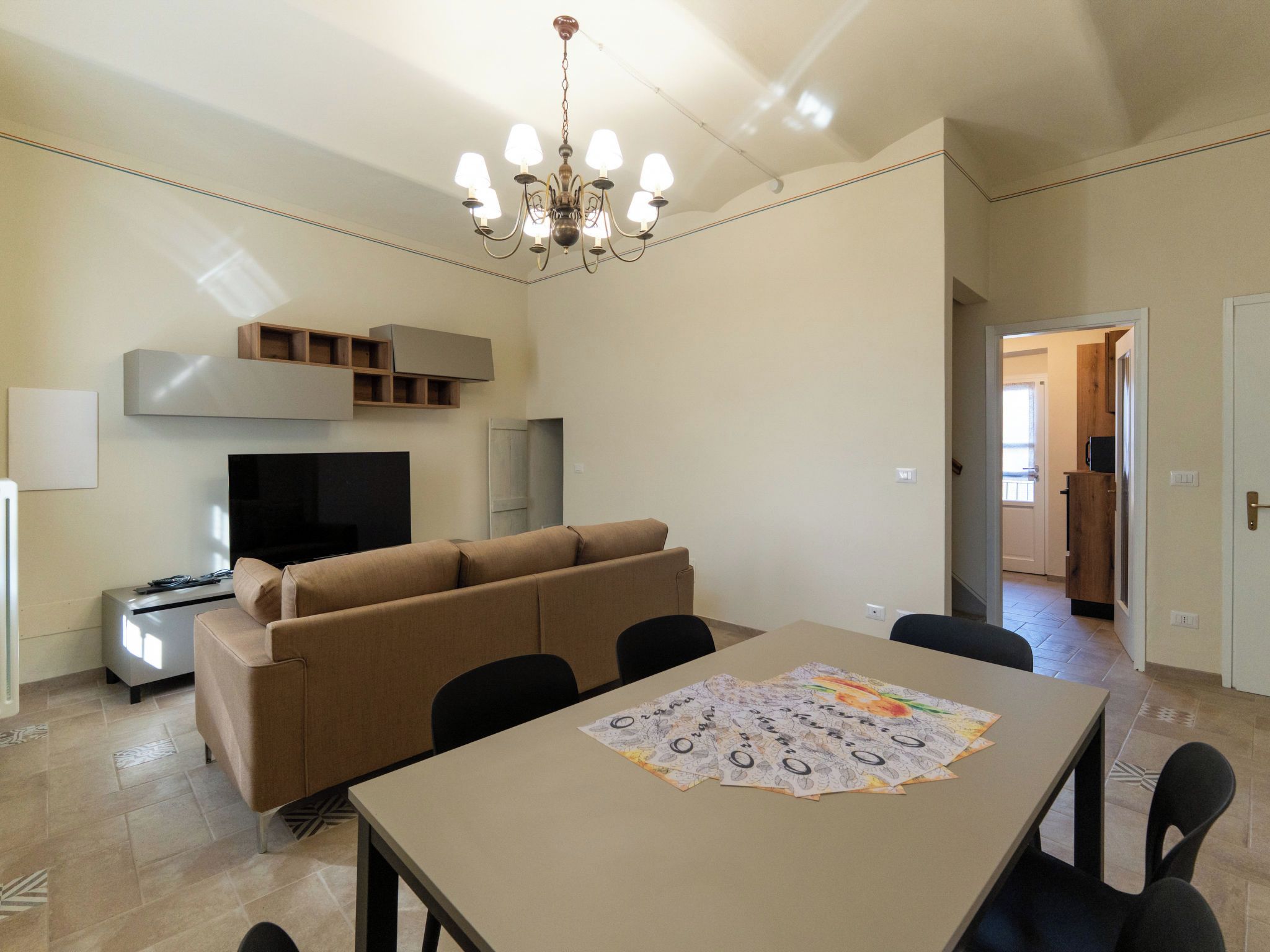 Un salon moderne avec un canapé, un téléviseur et une table à manger.
