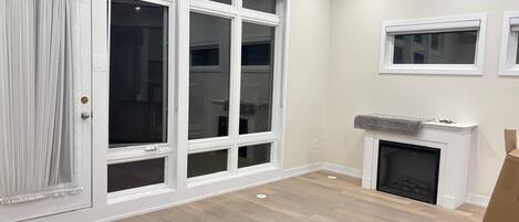 A room with a sliding glass door, a fireplace, and a small window.