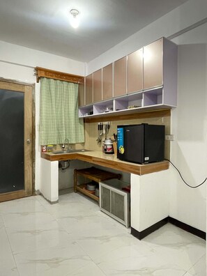 A compact kitchen with a built-in refrigerator, a sink, and a small countertop.