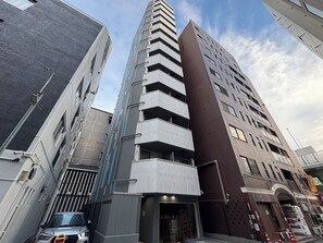 Ein mehrstöckiges Gebäude mit modernem architektonischen Design, das Balkone und große Fenster kombiniert.