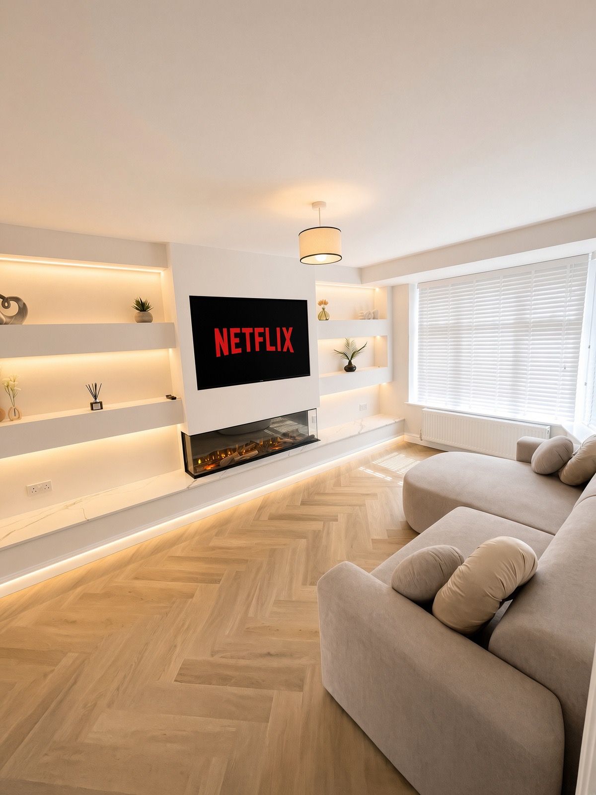 Ein modernes Wohnzimmer mit Flachbildfernseher an der Wand, einer Couch und einem Kamin.