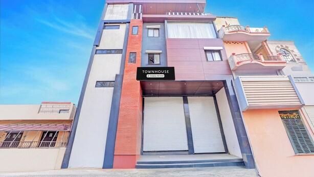 A multi-story building with a sign indicating 'TOWNHOUSE Company Serviced'. - Townhouse LIG Main Road Indore (Indore)