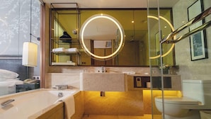 Un baño moderno con un espejo grande, una bañera, un inodoro y un lavabo.