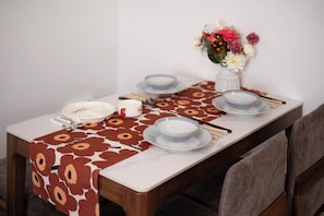 A dining table set with plates, bowls, chopsticks, and a vase with flowers. - The Peak Osaka Bay (Misaki , Minato-ku, Osaka City)