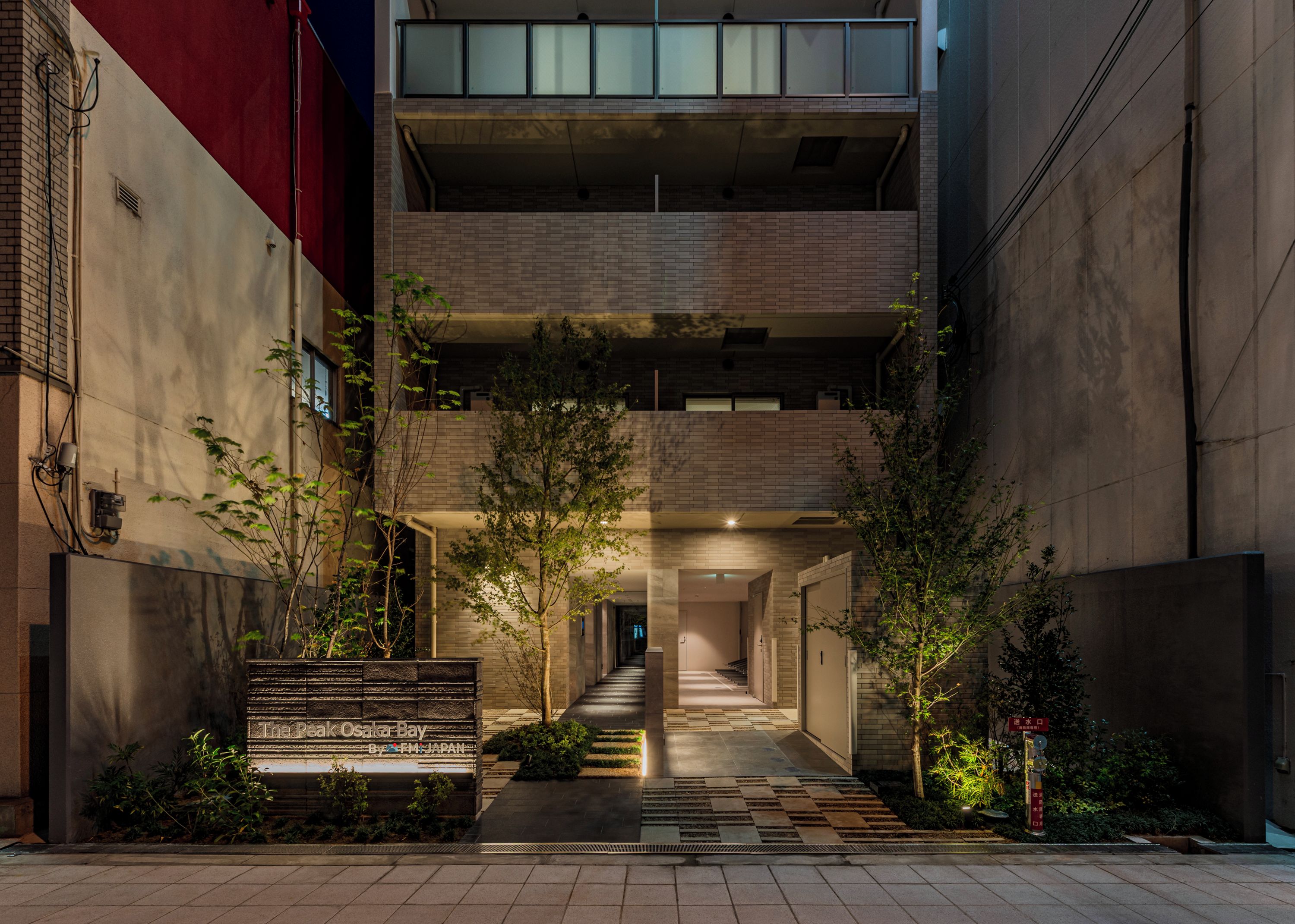 A multi-level building with a central courtyard, a staircase leading to the upper levels, and a sign indicating the location.