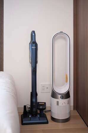 A vacuum cleaner and a trash bin on a wooden floor next to a bed. - The Peak Osaka Bay (Misaki , Minato-ku, Osaka City)