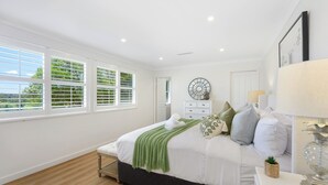 A bedroom with a bed, a dresser, a mirror, and a window with blinds. - Cosy 3 bedrooms Lane Cove 10 Mins to Sydney CBD (Lane Cove North)