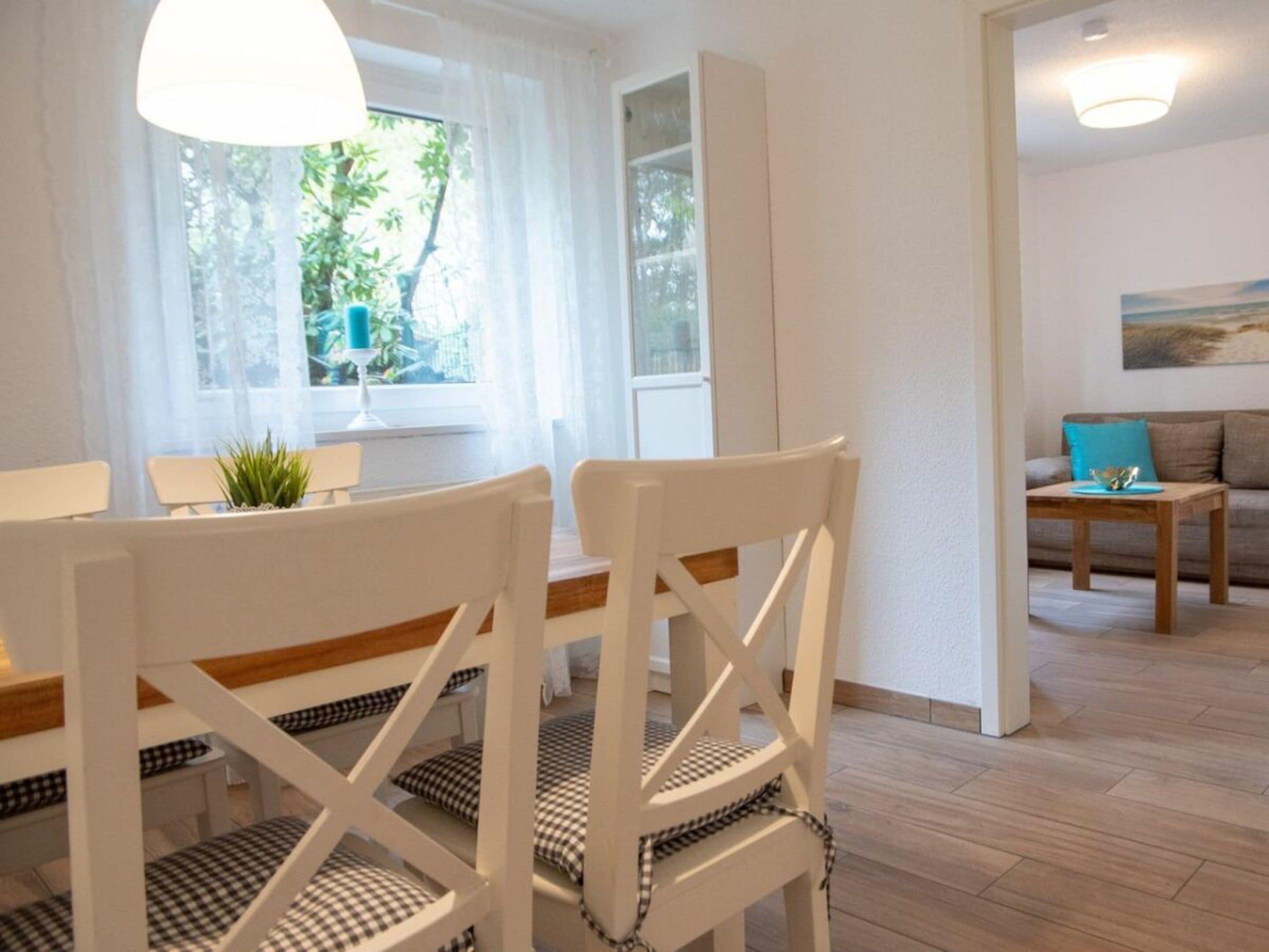 A modern living room with a dining area, featuring a sofa, a coffee table, and a dining table with chairs.
