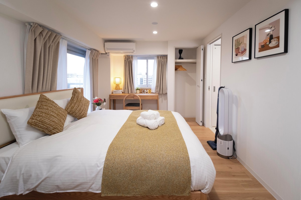 Ein Hotelzimmer mit einem Bett, einem Schreibtisch, einem Stuhl, einem Heizkörper und einer Tür zu einem Badezimmer.
