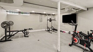 A gym with a stationary bike, weight bench, and various exercise equipment. - Newly renovated open concept home in Detroit, Mi. (Detroit)