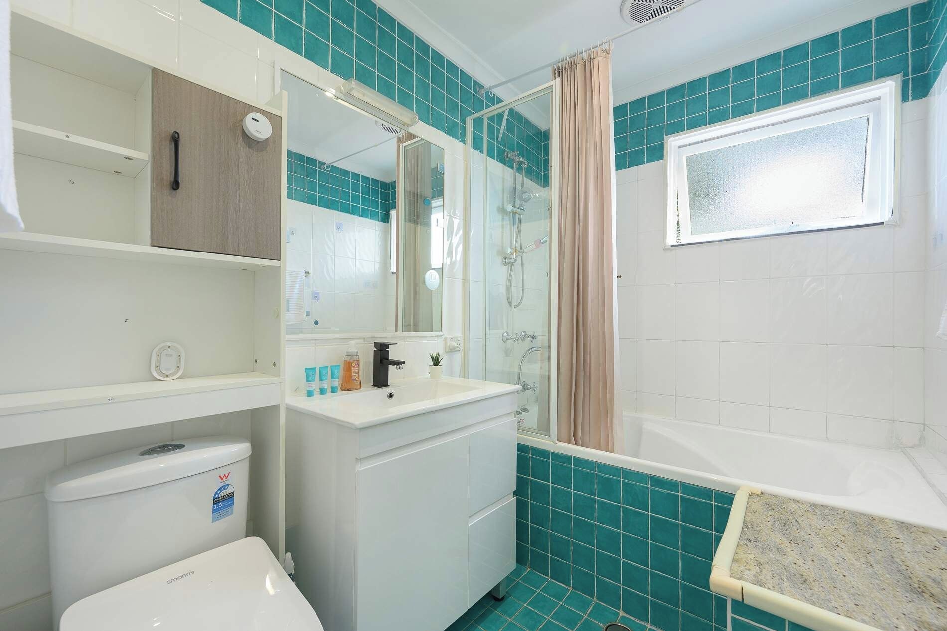 A bathroom with a shower, toilet, and sink.