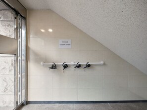 Un área de almacenamiento de equipaje con un cartel que indica su función, techo blanco y pared de azulejos.