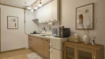 A modern kitchen with a built-in oven, microwave, and sink. There is a wooden cabinet with a glass door and a small refrigerator. A rug is on the floor, and a framed picture hangs on the wall.