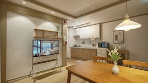 Eine moderne Küche mit Holzschränken, einer eingebauten Mikrowelle und einem Essbereich mit Holztisch und Stühlen.