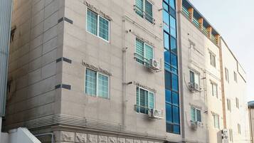 A multi-story building with a flat facade, large windows, and air conditioning units.