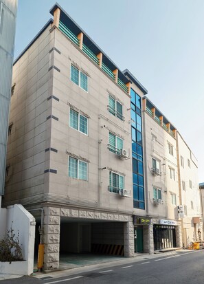 A multi-story building with a flat facade, large windows, and air conditioning units.