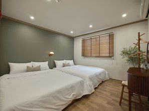 A bedroom with two beds, a wall-mounted lamp, a window with blinds, and a wooden chair. - SunYou Stay (Andong)