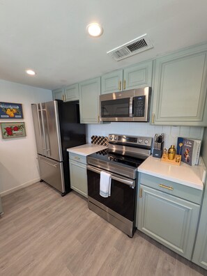 A kitchen with stainless steel appliances, light blue cabinets, and a white countertop. - Pool, Spa, & Games - Luxury Scottsdale Retreat Near Kierland (Scottsdale)