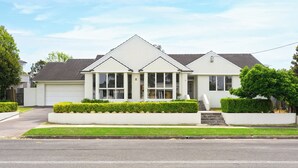 Ein zweigeschossiges Wohnhaus mit Garage, ein Veranda und einem gepflegten Rasen.