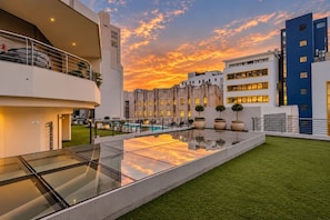 A hotel with a swimming pool, outdoor seating, and a sunset view. - Mandela Rhodes Sky Suite I Mountain & Pool Views (Cape Town)