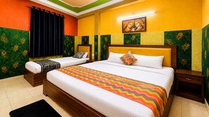 A hotel room with two beds, a large bed with a colorful zigzag bedspread, and a smaller bed with a patterned blanket. - The Viyan Vrindavan (Dhorera Khadar)