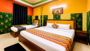 A hotel room with two beds, a colorful zigzag bedspread, and a painting above the beds. - The Viyan Vrindavan (Dhorera Khadar)