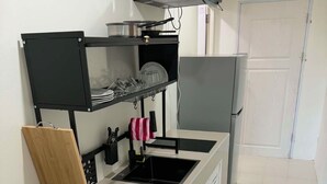 Une cuisine compacte équipée d’un lave-vaisselle, d’un four à micro-ondes et d’un réfrigérateur.