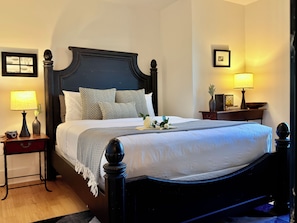 A hotel room with a large bed, a nightstand with a lamp, a bedside table, and a framed picture on the wall. - Water View 1BR near Brown & RISD, Parking + Elevator (Providence)