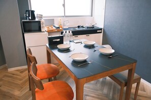 Cozinha moderna com mesa de jantar, cadeiras e diversos eletrodomésticos.