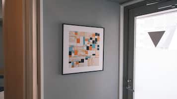 A framed abstract artwork on a wall near a door.