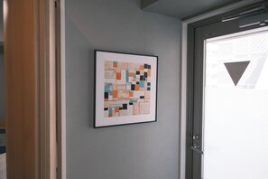 Abstract kunstwerk in een lijst op een muur nabij een deur.