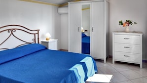 A bedroom with a bed, a wardrobe, a bedside table, and a nightstand. - Il Frantoio (Massa Lubrense)