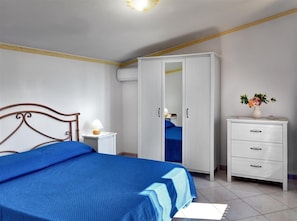 A bedroom with a bed, a wardrobe, a bedside table, and a nightstand. - Il Frantoio (Massa Lubrense)