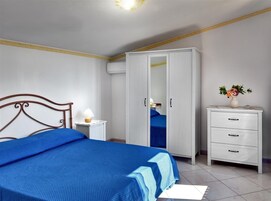 Un dormitorio con una cama, un armario, una mesita de noche y un tocador.