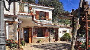 A two-story building with a balcony, a wooden pergola, and a stone facade. - Il Frantoio (Massa Lubrense)