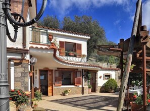 A two-story building with a balcony, a wooden pergola, and a stone facade. - Il Frantoio (Massa Lubrense)