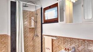 A bathroom with a shower, a sink, and a mirror. - Il Frantoio (Massa Lubrense)