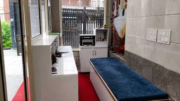 Una kitchenette compacta con encimera, pileta y pequeño refrigerador.
