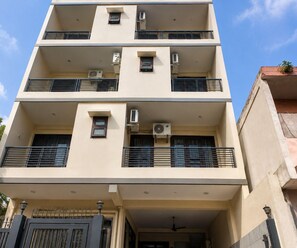 A multi-story building with balconies, air conditioning units, and a gated entrance. - Deluxe GG Residency (Mohali)