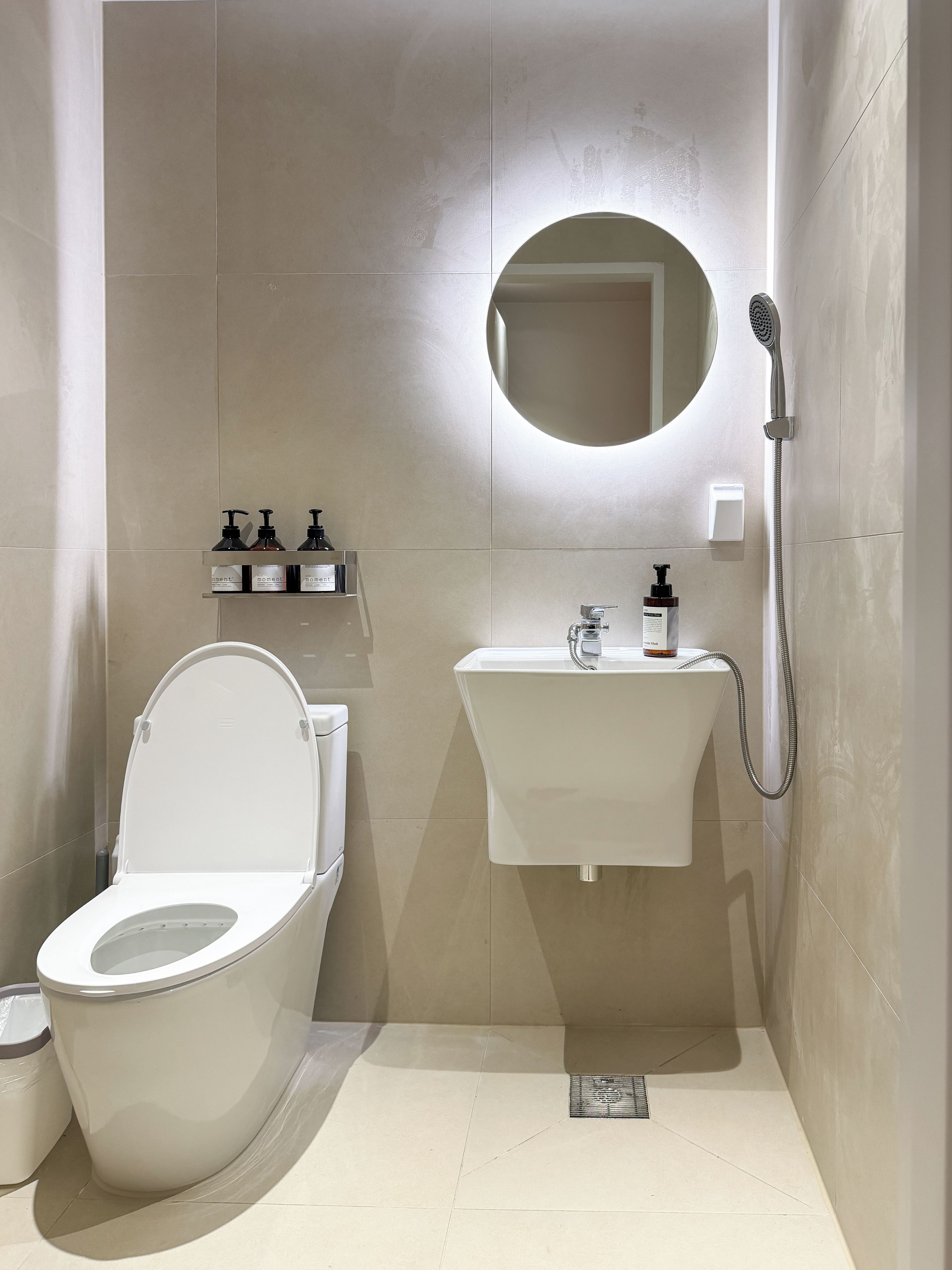 Un baño moderno con inodoro, lavamanos y ducha.