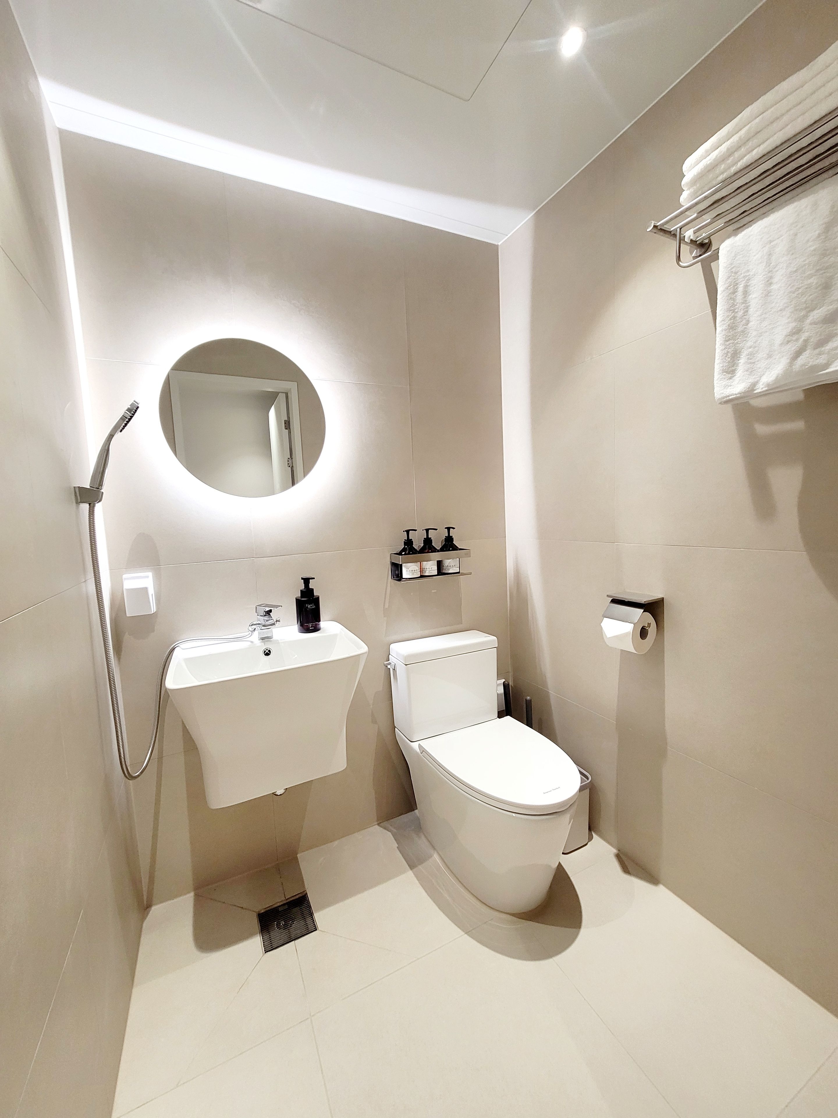 A modern bathroom with a toilet, sink, and shower.