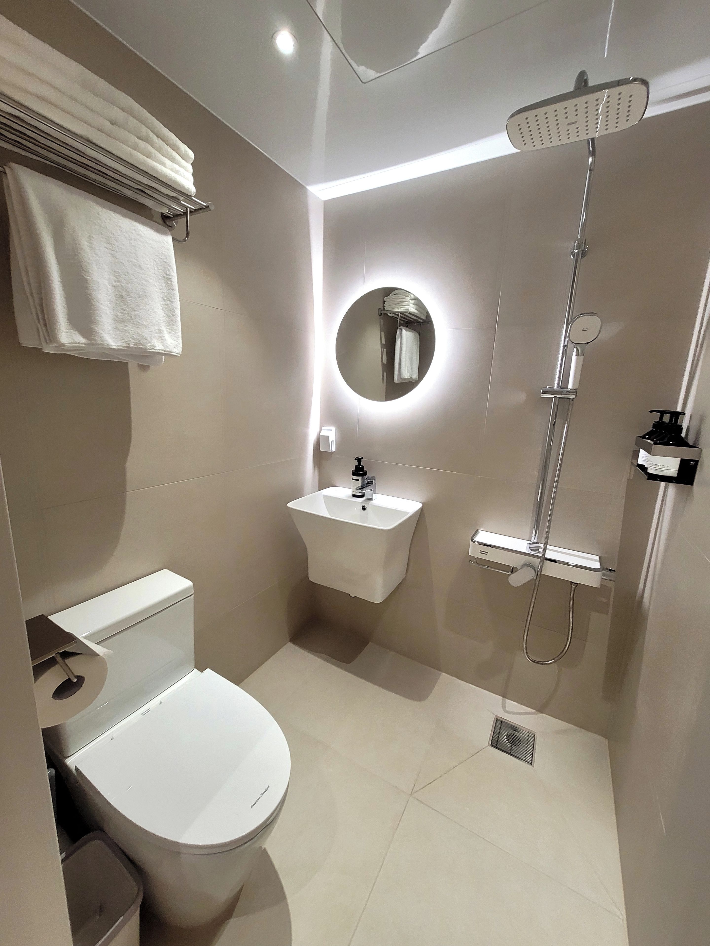 A modern bathroom with a toilet, sink, and shower.