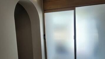 A hallway with a spa sign, a green emergency exit sign, and a sliding glass door.