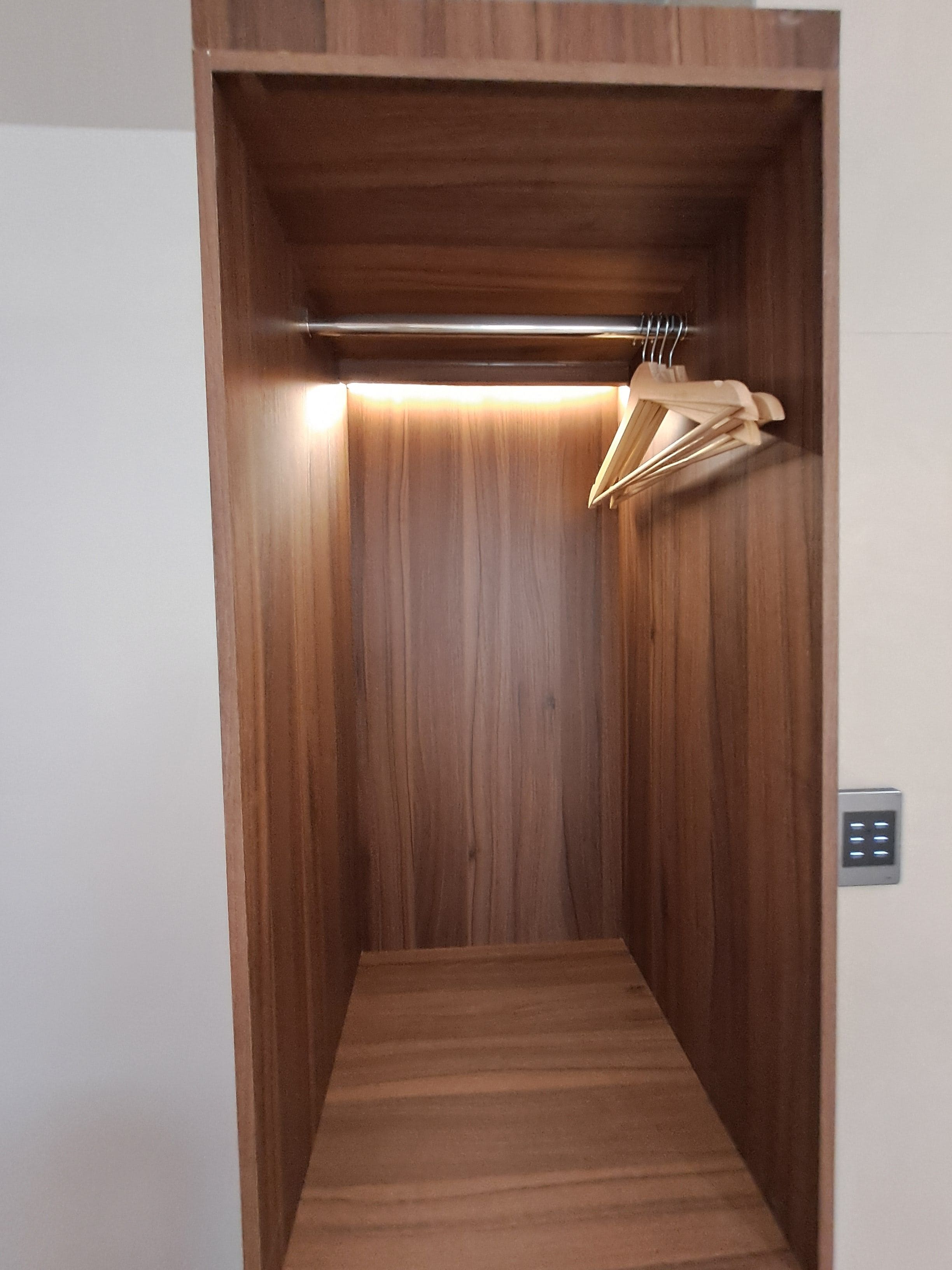 A wooden interior with a flat floor, a light fixture, and a wall-mounted control panel.
