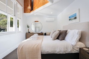 A bedroom with a bed, bedside table, mirror, and a window. - The An Chroi Estate by Homello (Bombay)